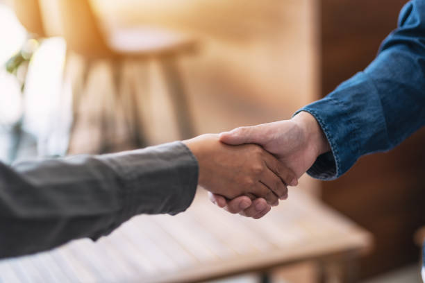 two people shaking hands Closeup image of two people shaking hands casual handshake stock pictures, royalty-free photos & images