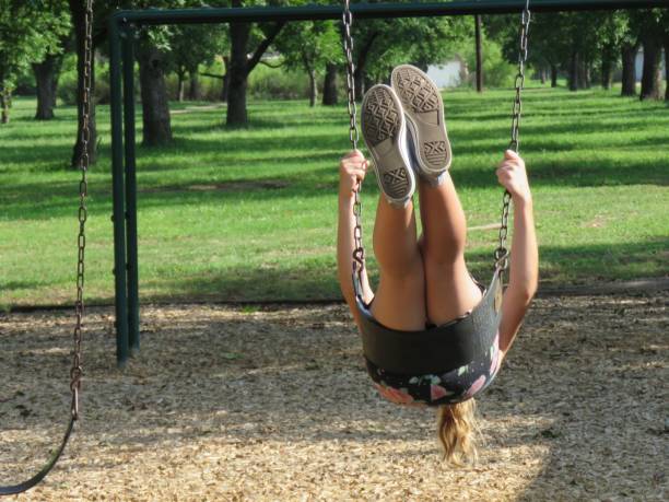 istock girl swinging on playground equipment 1159306322