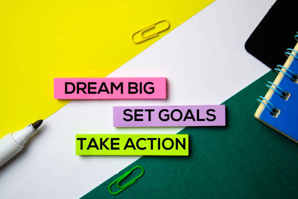 istock Dream Big. Set Goals. Take Action text on sticky notes with office desk concept 1159307240