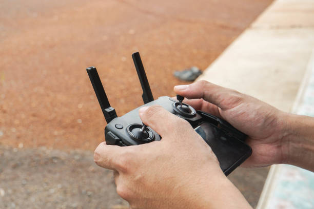 close up man play Drone by remote control joystick with smartphone at home as hobby