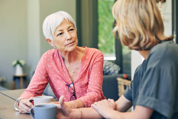 Mom will always be there to listen Shot of a mature woman and her elderly mother having coffee and a chat at home serious talk stock pictures, royalty-free photos & images