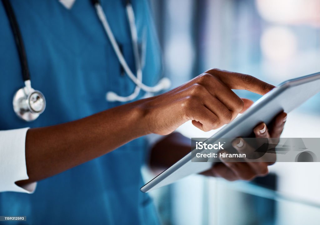 Eliminating delays in patient care with digital technology Cropped shot of a doctor using a digital tablet in a hospital Doctor Stock Photo
