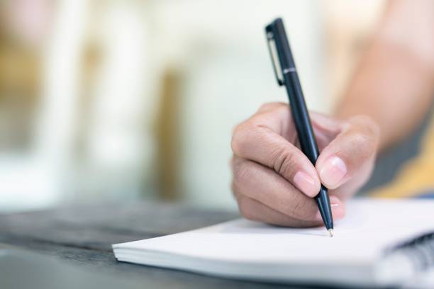 istock Women holding a pen writing a notebook. Recording concept. 1159316182