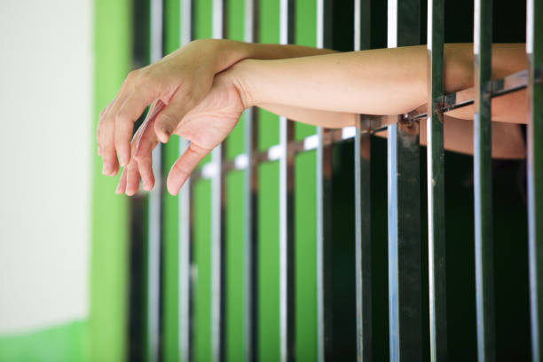 istock close up of hands in jail background. 1159316294