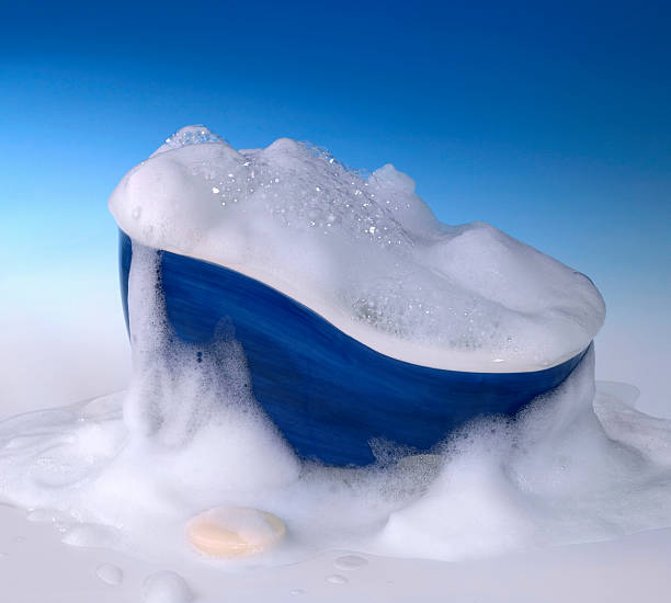 bathtub and foam symbolic cleaning and washing background with bathtub,soap and lots of foam in blue gradient back free standing bath photos stock pictures, royalty-free photos & images