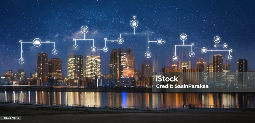 Smart city, internet wireless and networking in the city. Modern city at night with internet network and online media application icons Real Estate Stock Photo