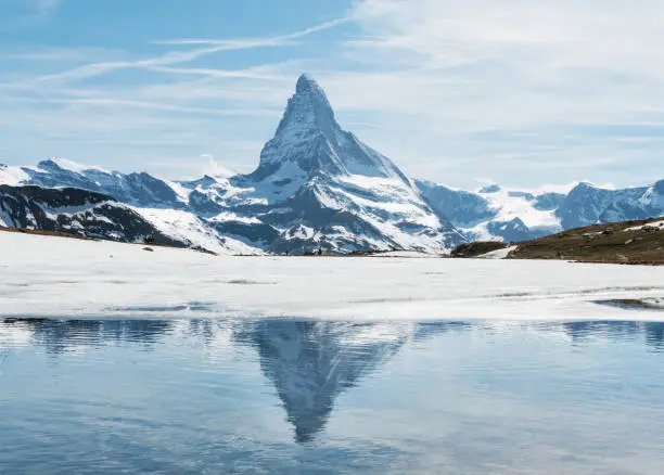 Matterhorn mountain with reflection on melting frozen lake in Zermatt, Switzerland
