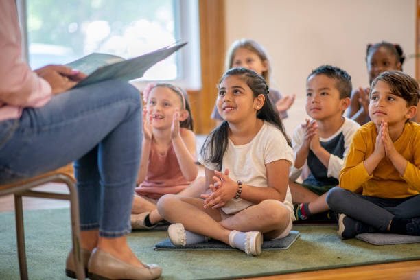 istock Diverse group of students listening to their teaching reading a story 1159321581