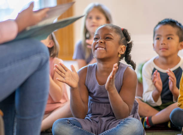 istock Diverse group of students listening to their teaching reading a story 1159321585