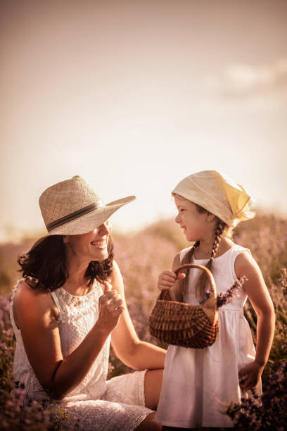 istock Mother and daughter playing in a wildflower  field 1159324113