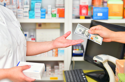Customer paying for Medicaments with  100 dollar bill in pharmacy drugstore