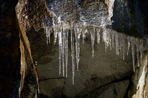 Icicles forming on rock stock photo