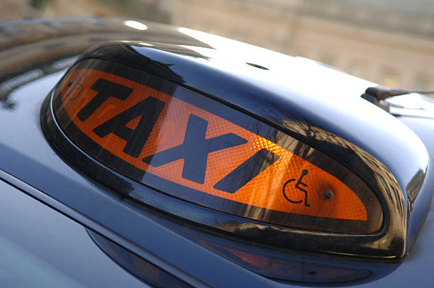 A British black cab sign illuminated which indicates the taxi is available for hire. The sign incorporates a standard wheelchair design showing teh vehicle has disabled access. No sharpening.