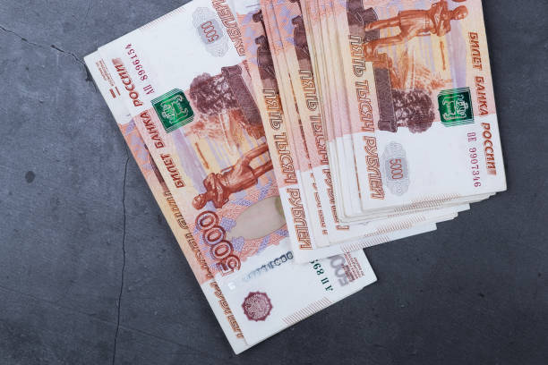 istock Big stack of Russian money banknotes of five thousand rubles lying on a grey cement background. 1159332308