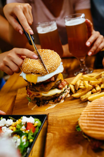 istock Cutting oversized burger in fast food restaurant 1159333488