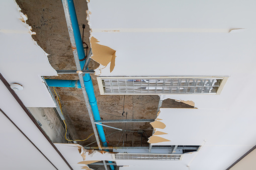reparar la tubería de agua de fuga en el edificio de oficinas interiores del techo de yeso photo