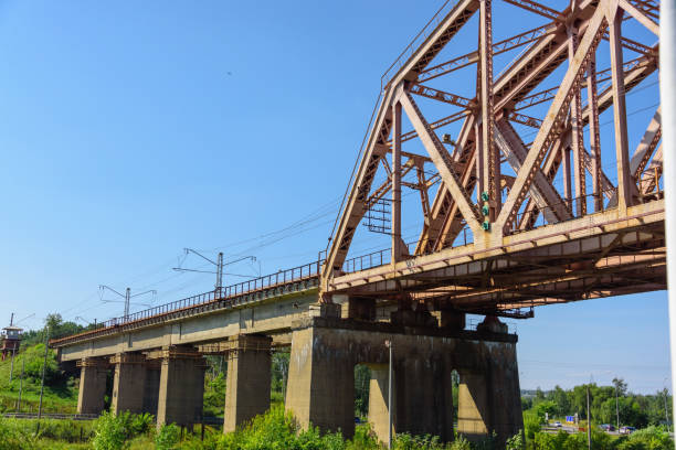 istock passenger train is traveling along the railway bridge over the river. 1159334530