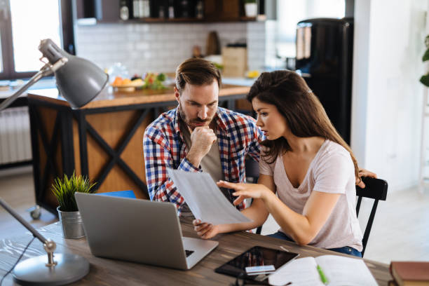 frustrated couple checking bills at home using laptop - frustration emotional stress surprise women imagens e fotografias de stock