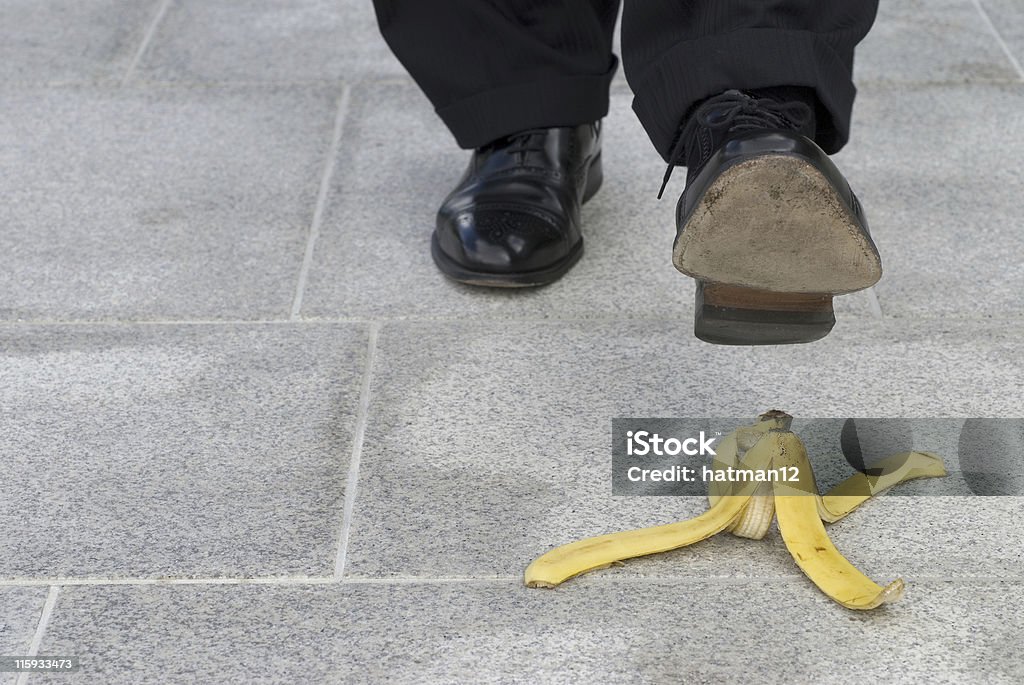 Uomo d'affari e banana pelle incidente - Foto stock royalty-free di Abbigliamento elegante