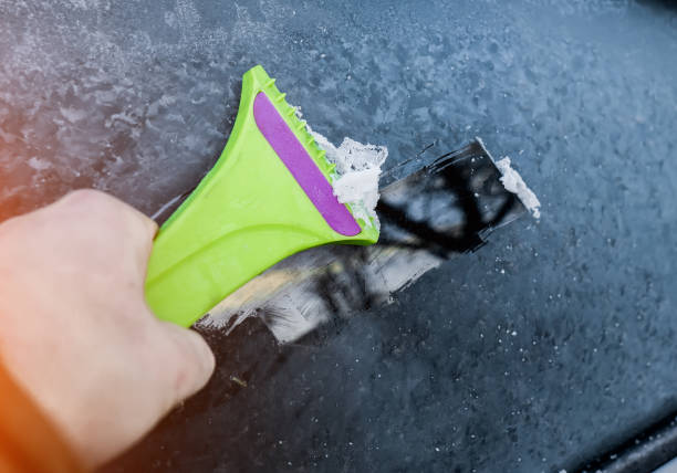 istock Cleaning snow from windshield, Scraping ice, Winter car window cleaning 1159335599