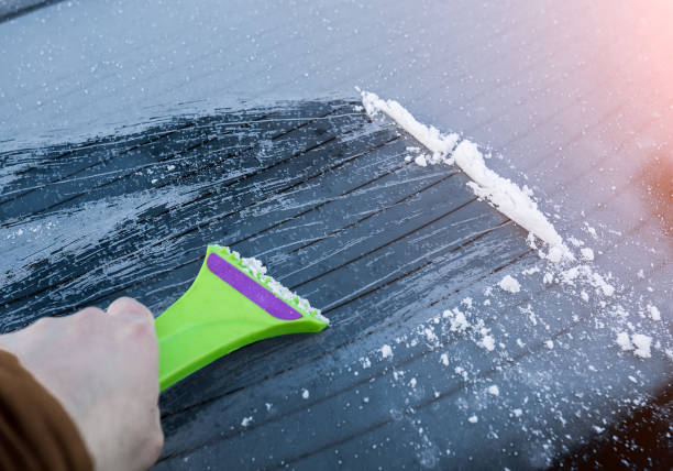 istock cleaning the glass machine from snow and ice brushing. 1159335690