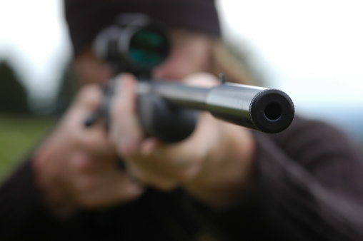 Hunter aiming through the scope of his rifle.