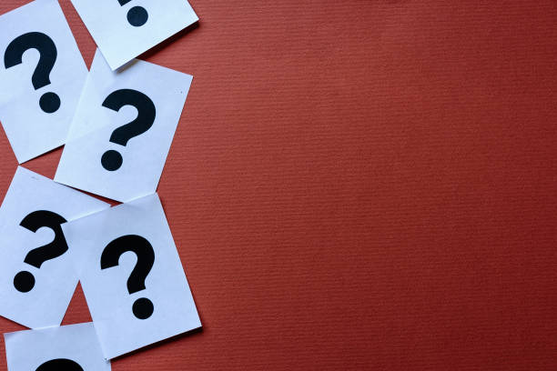 istock Border of printed question marks on white cards 1159337950