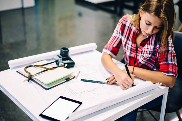 istock Professional female architect drawing blueprint of construction using stationery and equipment at desktop, creative girl studying design courses in college making drafting sketches for homework 1159338417