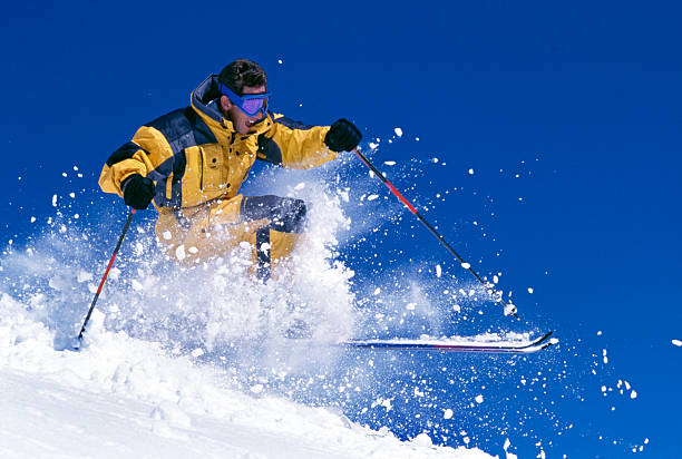 Man Snow Skiing Against Blue Sky stock photo