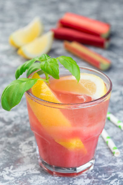istock Refreshing lemonade with rhubarb, lemon, sparkling water and basil in a glass, vertical 1159340525