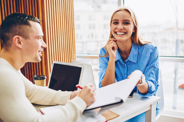 istock Cheerful blonde woman worker happy about completing project successfully cooperating with colleague, young male and female partners working together in friendly atmosphere doing creative job in office 1159340617