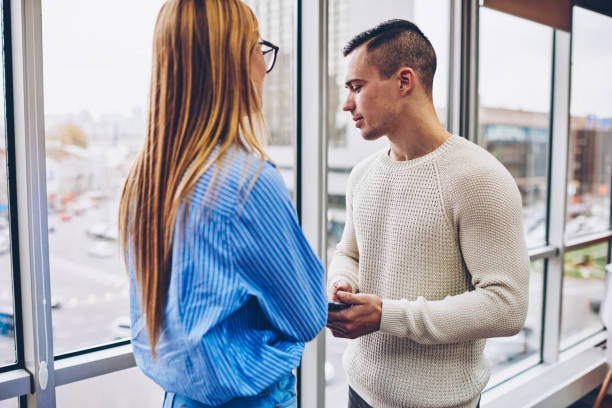 istock Male and female colleagues communicating making solutions of working project sharing ideas, cowokers having friendly conversation during break standing near window in modern interior office 1159340680