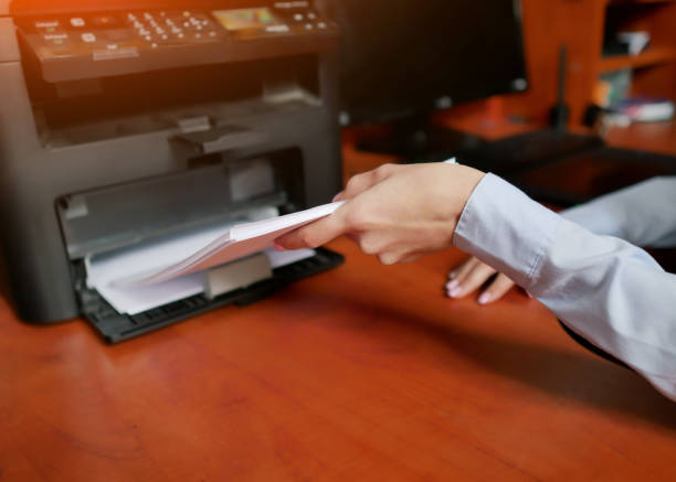 istock Human hand is reloading the paper to printer tray 1159341006