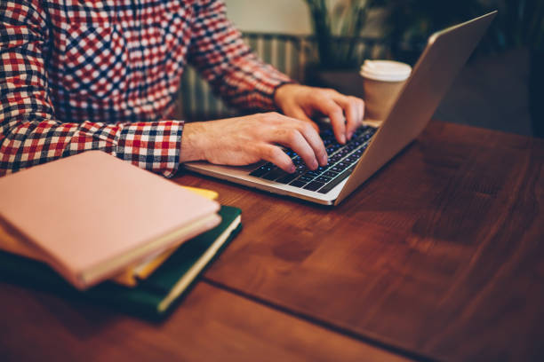 istock Cropped image of male hands installing application for studying online while searching courses on internet websites, man doing course work via modern laptop computer connected to university wifi 1159341072