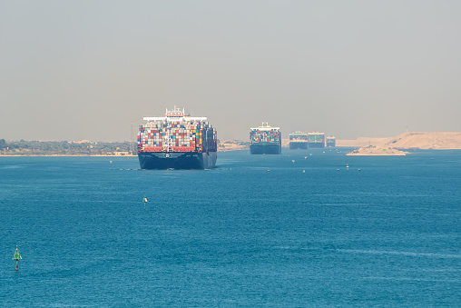 Suez, Egypt - November 5, 2017: Large container vessels (ship) passing Suez Canal in the sandy haze in Egypt.