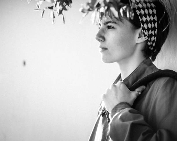 istock Young woman leaning on white wall 1159343186