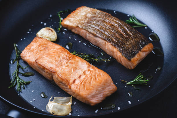 bifes salmon grelhados na frigideira com alho e rosemary - cooked pepper salmon food - fotografias e filmes do acervo