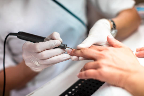 istock Using a rotary nail manicure tool to remove excess skin off a fingernail 1159345567