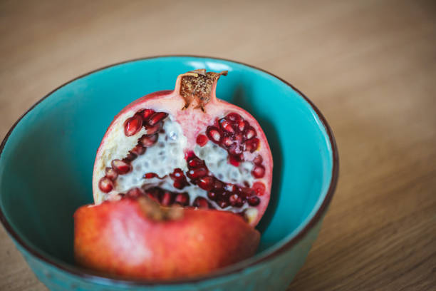 istock Pomegranate fruit in two halves in a blue bowl. 1159346209