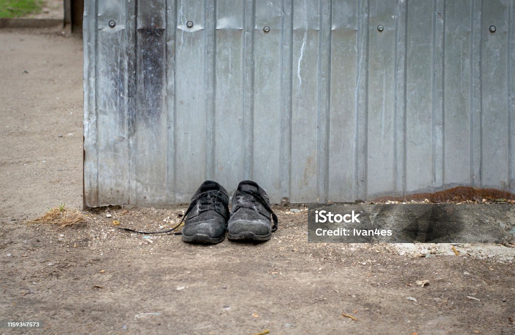 Discarded shoes. Old shoes by the dumpster. Abstract Stock Photo