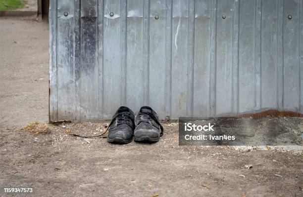 Discarded Shoes Old Shoes By The Dumpster Stock Photo - Download Image Now - Abstract, Black Color, Boot