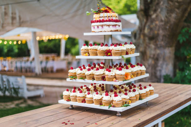 istock Many cupcakes with white cream and strawberries on a wooden table 1159347632