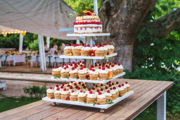 istock Many cupcakes with white cream and strawberries on a wooden table 1159347635