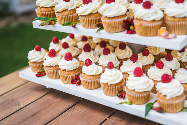 istock Many cupcakes with white cream and strawberries on a wooden table 1159347676