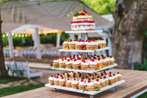 istock Many cupcakes with white cream and strawberries on a wooden table 1159347679