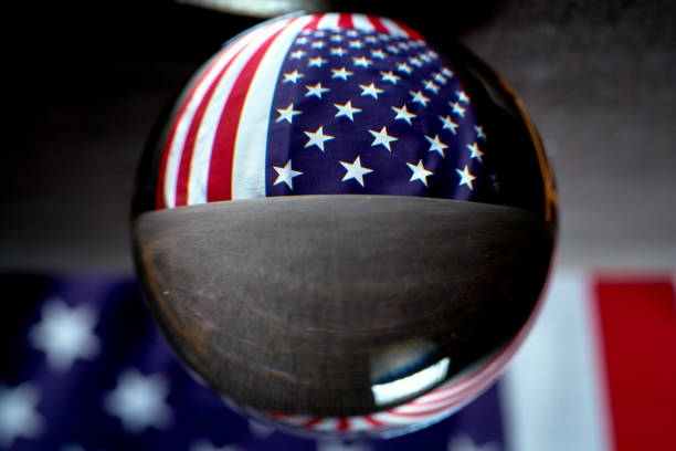 istock us flag on a black background visible through a glass ball 1159349856