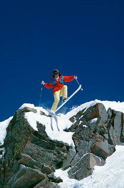 istock Snow Skier Jumping from Rock Cliff 115935003