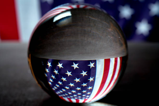 istock us flag on a black background visible through a glass ball 1159350257