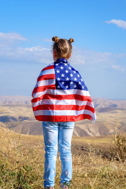 patriotic holiday. happy kid, cute little child girl with american flag. usa celebrate 4th of july. - child flag fourth of july little girls imagens e fotografias de stock