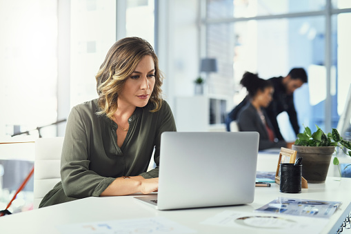 Shot of a young businesswoman using a laptop in an office